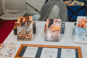 A table display featuring Tiffany Marks’ romance novels Chasing the Truth, Runaway, and Secret in the Shadows at Foothills Book Fest.
